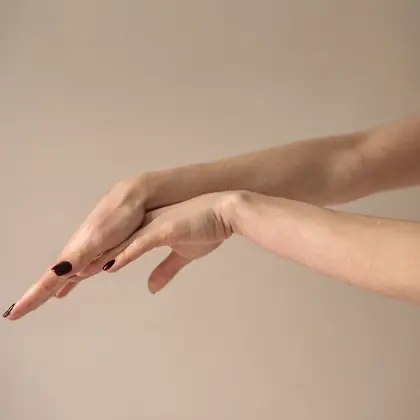 Symbolfoto: eine ruhig gehaltene Hand vor einem warm beigen Hintergrund.